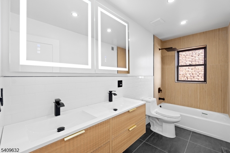 477 15th Avenue, Unit 2 Newark, NJ 07103 - Photo 7 of 11 a bathroom with a tub sink toilet and mirror