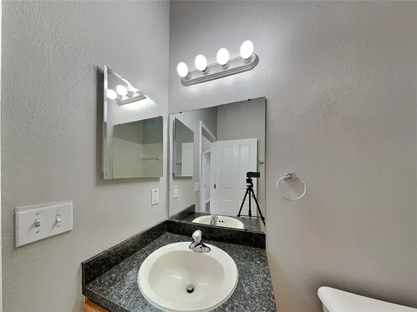 a bathroom with a sink a toilet and mirror