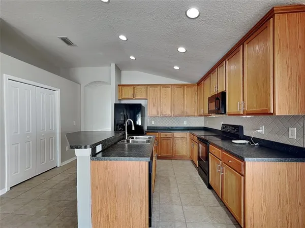 a kitchen with stainless steel appliances granite countertop a sink stove and cabinets