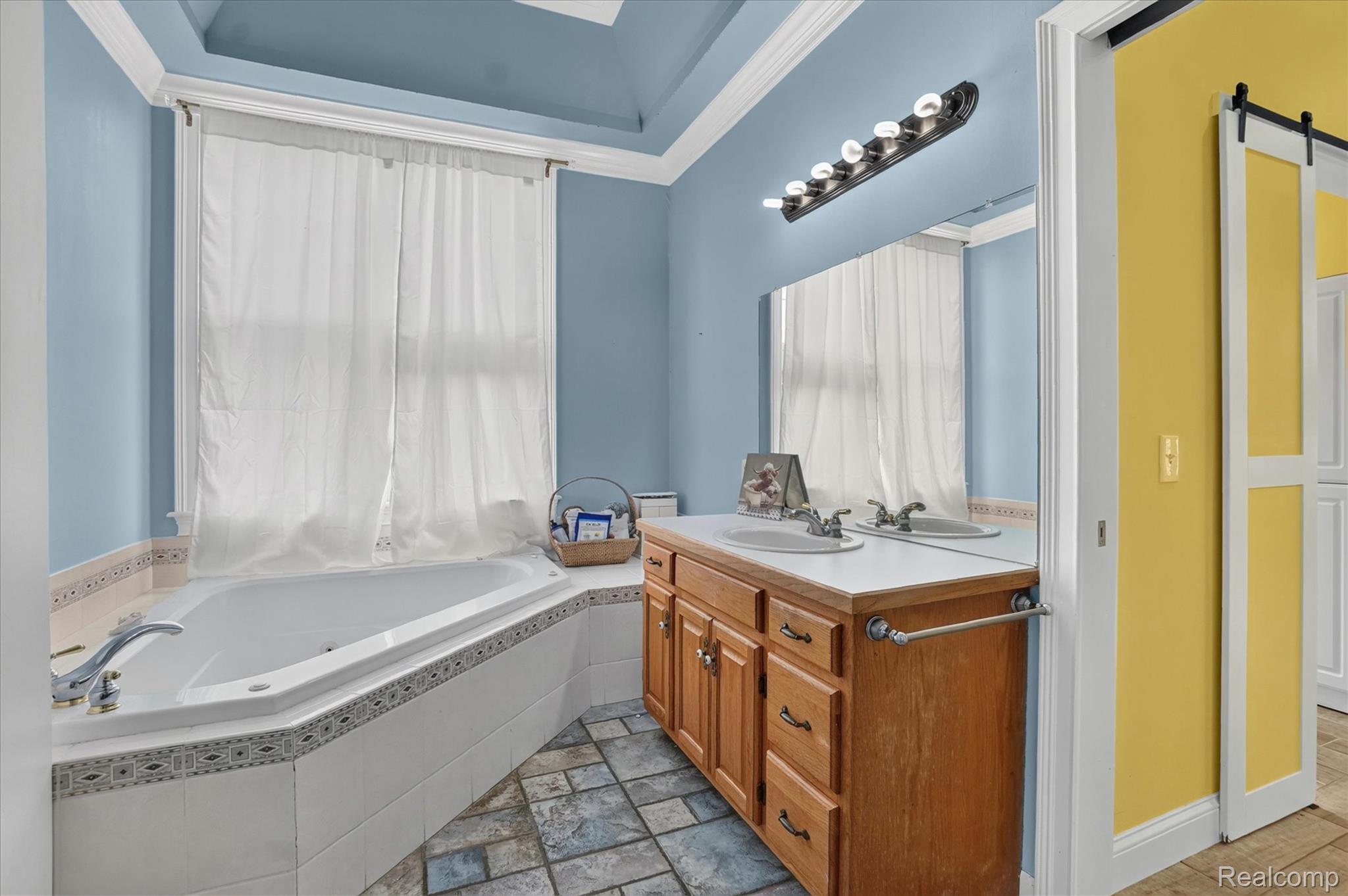 6524 Kelly Road Flushing, MI 48433 - Photo 30 of 47 Bathroom featuring a corner soaking tub, a dual vanity with wood cabinetry, and a large mirror