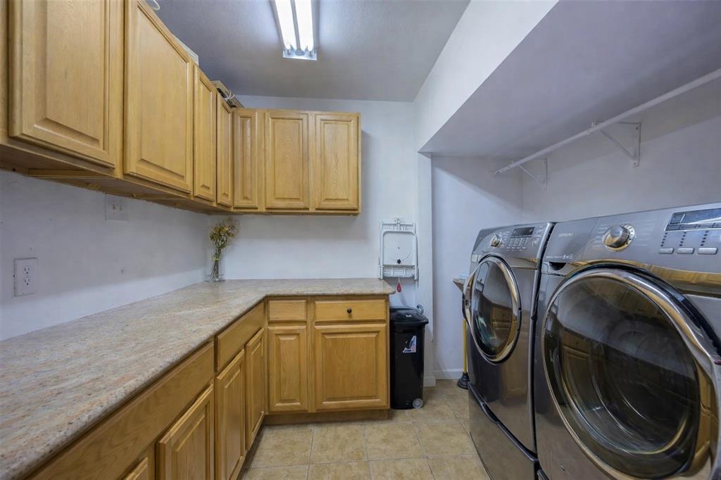 9835 Estate Lane Dallas, TX 75238 - Photo 15 of 25 Laundry area with separate washer and dryer, cabinet space, and light tile patterned floors