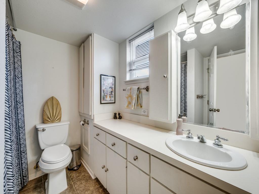 9835 Estate Lane Dallas, TX 75238 - Photo 22 of 25 Bathroom featuring a shower with curtain, vanity, and dark tile patterned floors