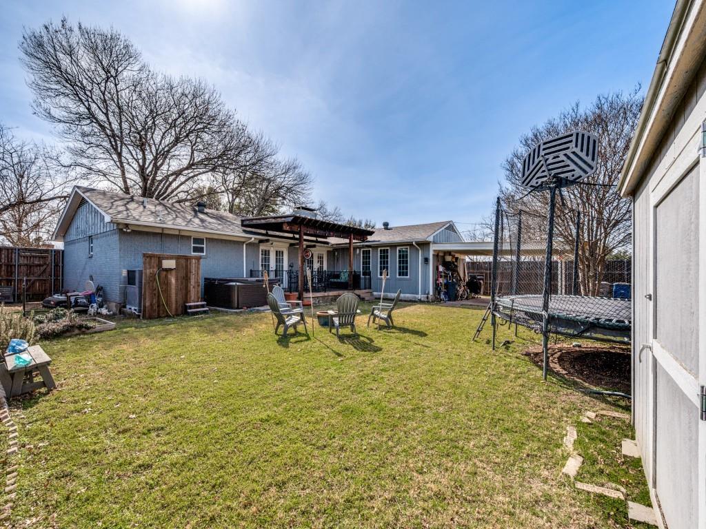 9835 Estate Lane Dallas, TX 75238 - Photo 24 of 25 Fenced backyard with a hot tub, a trampoline, a patio area, an attached carport, and a pergola