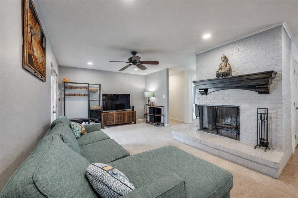 9835 Estate Lane Dallas, TX 75238 - Photo 5 of 25 Carpeted living area with a fireplace, ceiling fan, and recessed lighting