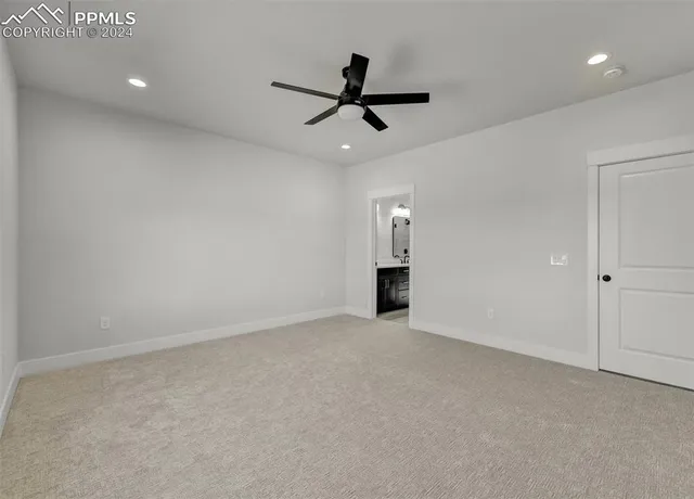 an empty room with ceiling fan and windows