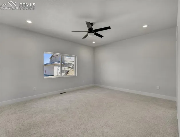 en empty room with windows and ceiling fan