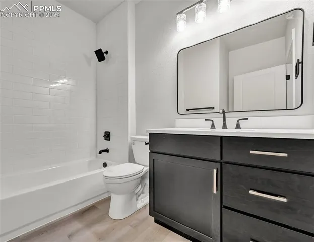 a bathroom with a bathtub shower sink vanity and toilet