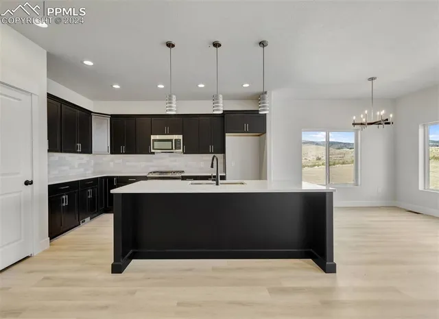 a large kitchen with stainless steel appliances a large counter top