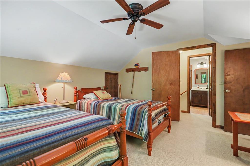 102 Moses Road Rabun Gap, GA 30568 - Photo 23 of 40 a bedroom with two beds and a chandelier