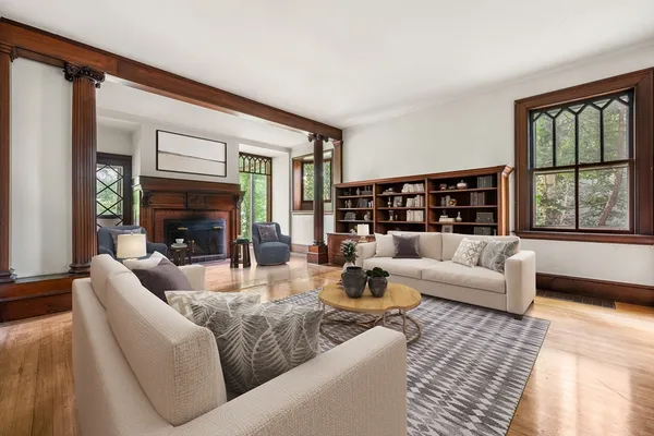 a living room with fireplace furniture and a large window