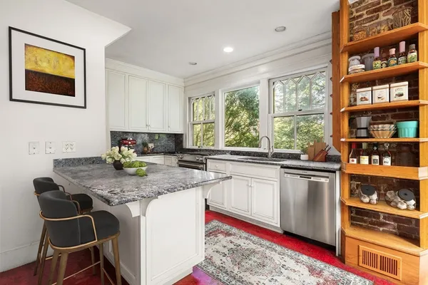 a kitchen with stainless steel appliances granite countertop a stove a sink and a microwave