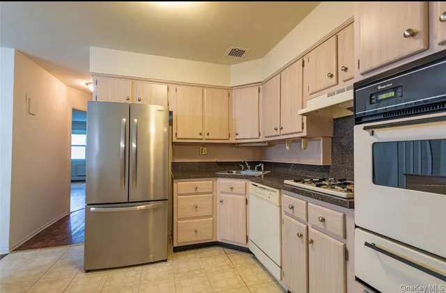 a kitchen with stainless steel appliances a refrigerator sink and cabinets