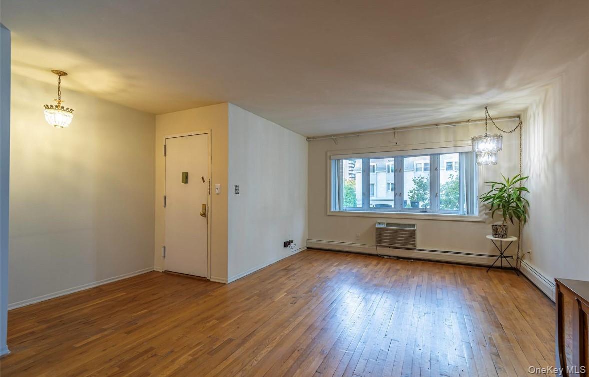 18-16 Bell Boulevard, Unit 2 Queens, NY 11360 - Photo 4 of 8 an empty room with wooden floor and windows
