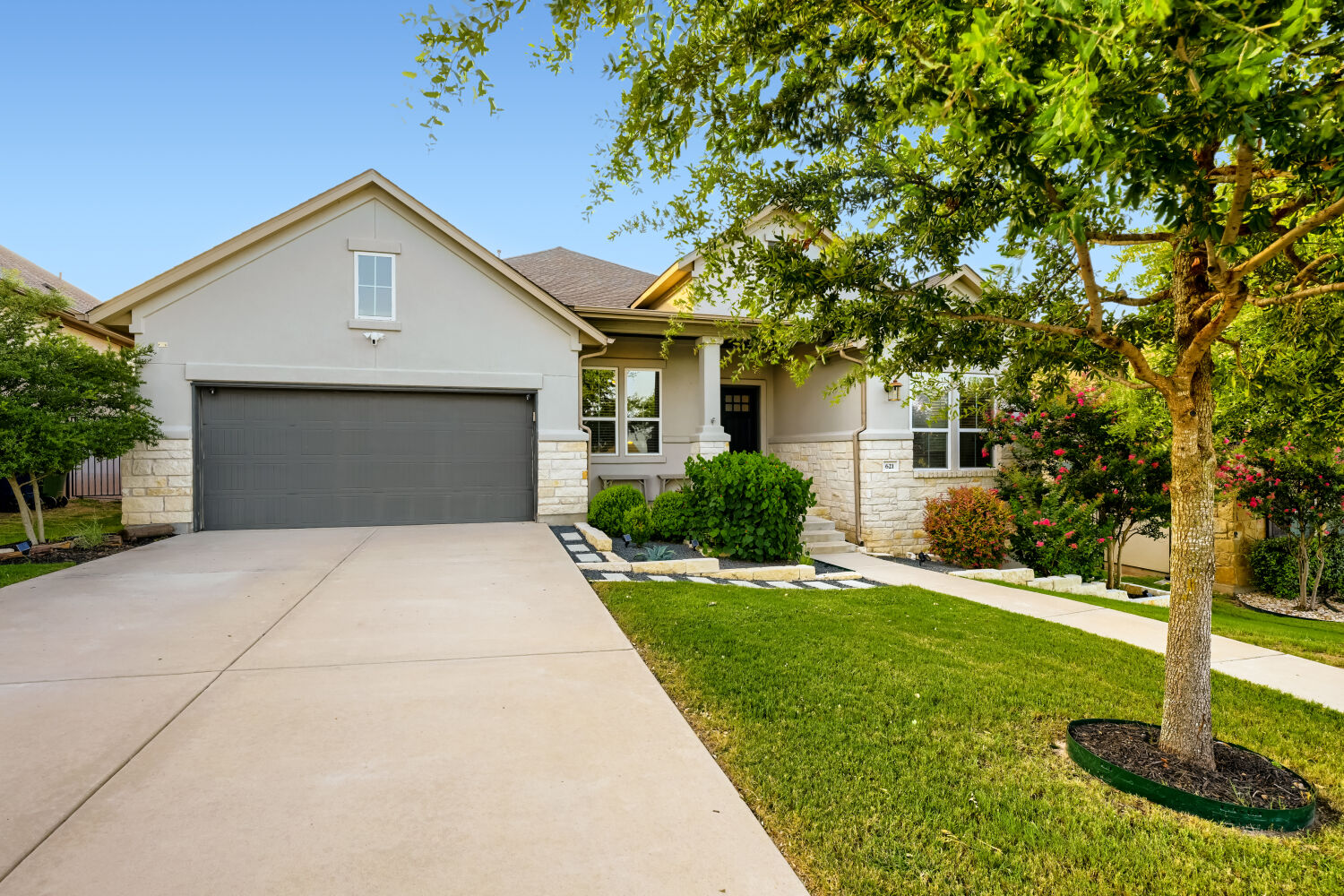 621 Rancho Sienna Loop Georgetown, TX 78628 - Photo 2 of 28 A well-maintained lawn and mature trees frame this inviting single-story residence with an attached garage.