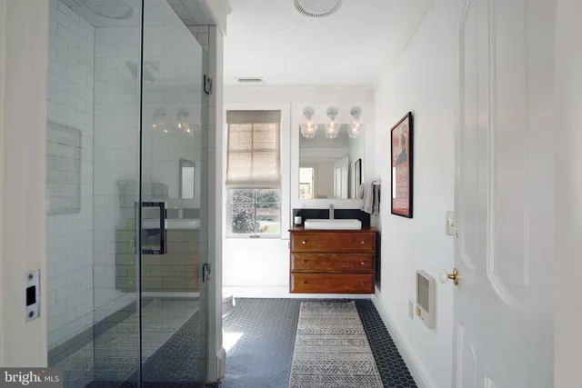 a bathroom with a granite countertop sink mirror and shower