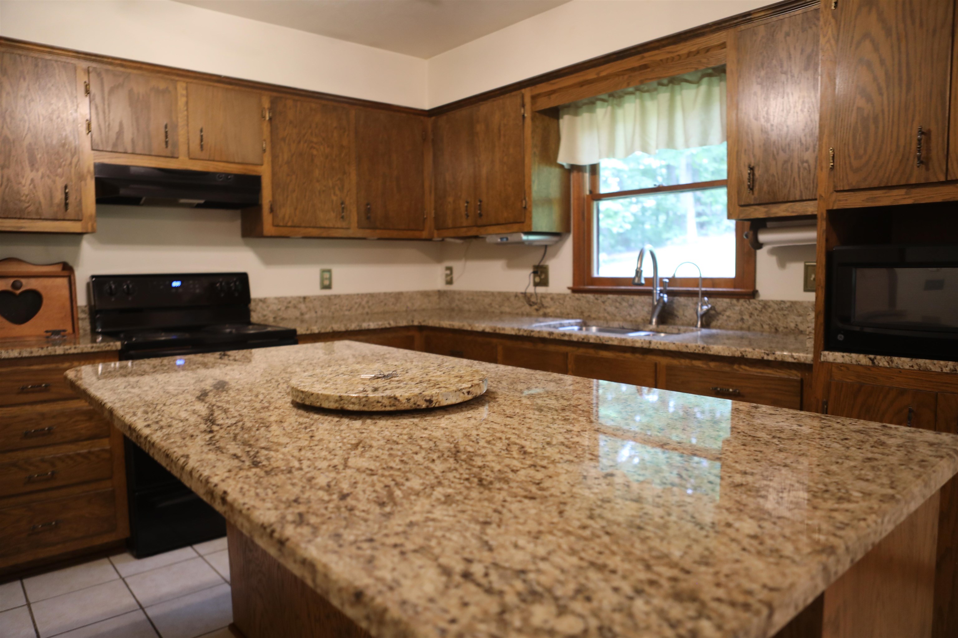 573 Round Hill School Road Fort Defiance, VA 24437 - Photo 30 of 65 a kitchen with granite countertop a sink a stove and a wooden cabinets