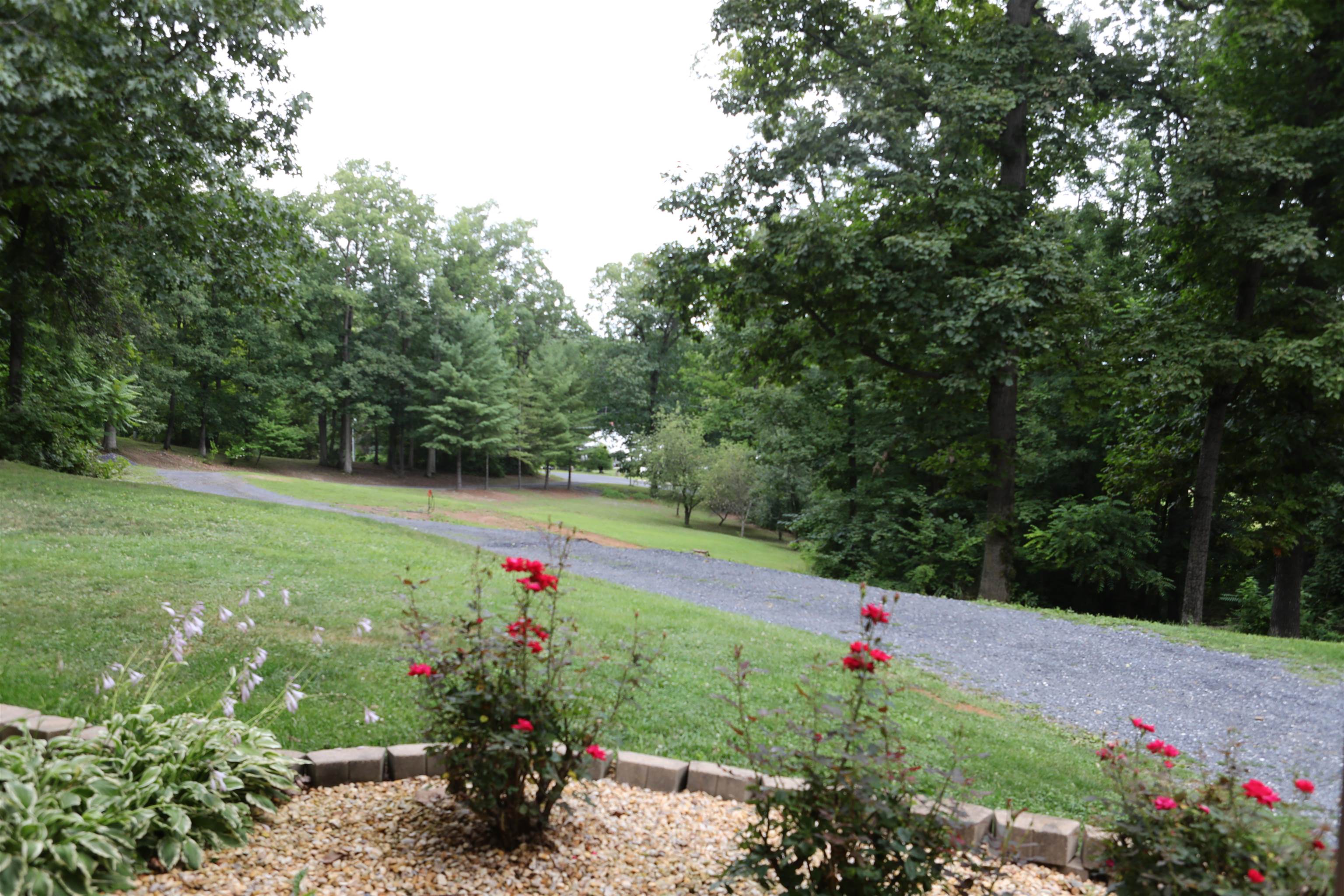 573 Round Hill School Road Fort Defiance, VA 24437 - Photo 8 of 65 a view of a garden with flowers and wooden fence