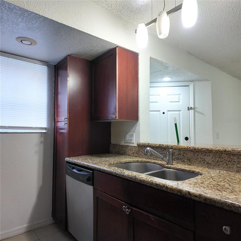 5152 Conroy Road, Unit 1317 Orlando, FL 32811 - Photo 15 of 21 a kitchen with a sink and a refrigerator