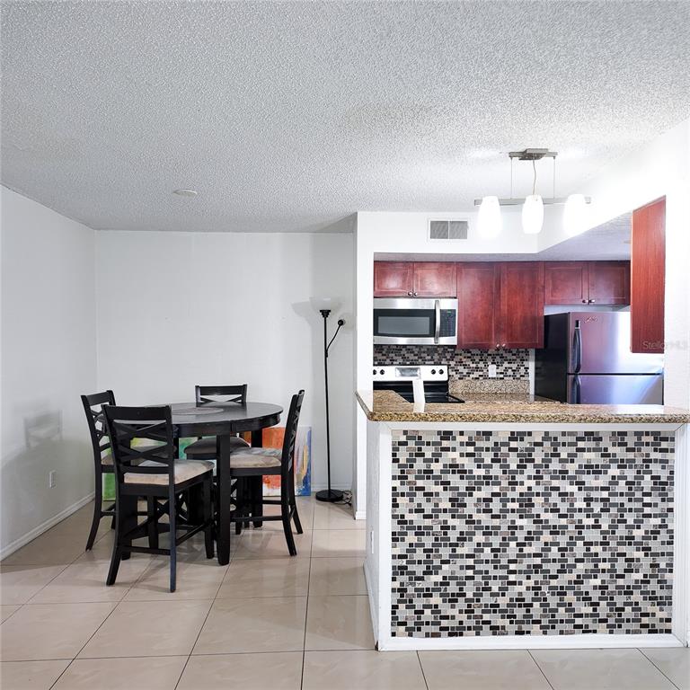 5152 Conroy Road, Unit 1317 Orlando, FL 32811 - Photo 7 of 21 a kitchen with a table and chairs in it