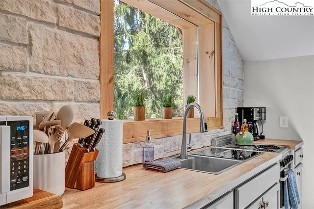 a kitchen with a sink and a stove next to a window