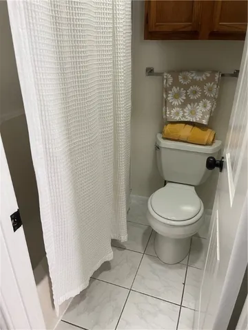 a white toilet sitting next to a shower