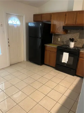 a kitchen with a refrigerator and cabinets