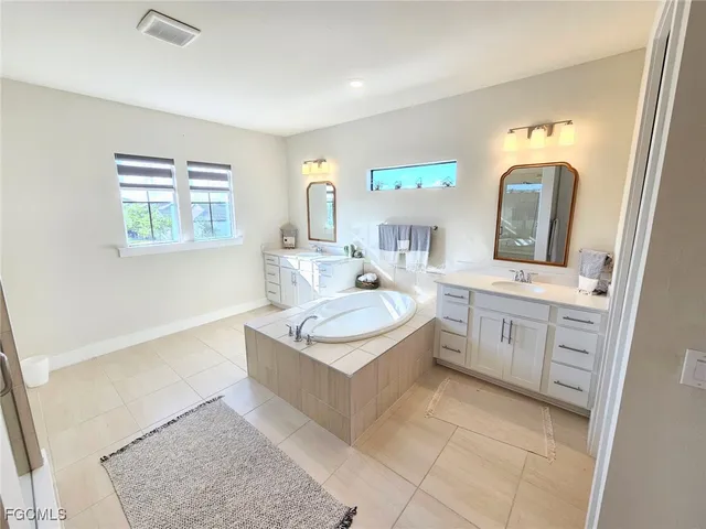 a spacious bathroom with a tub shower and sink