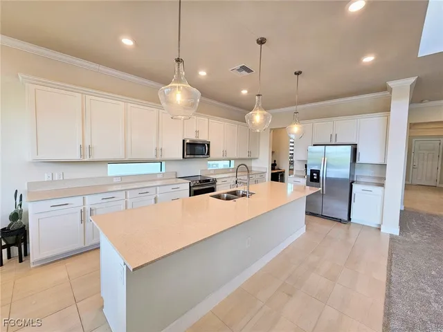 a large kitchen with kitchen island a stove a sink a center island and cabinets