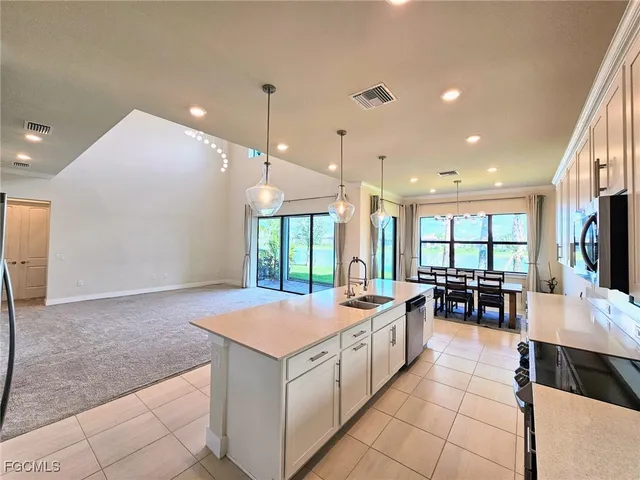 a large kitchen with kitchen island a stove a sink a dining table and chairs