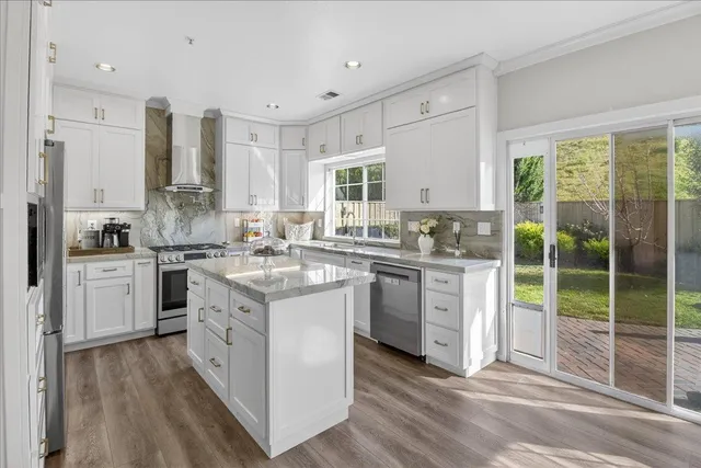 a kitchen with stainless steel appliances granite countertop a sink refrigerator and cabinets