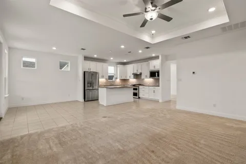 a kitchen with granite countertop white cabinets and stainless steel appliances