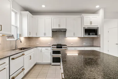 a kitchen with stainless steel appliances granite countertop a sink and cabinets