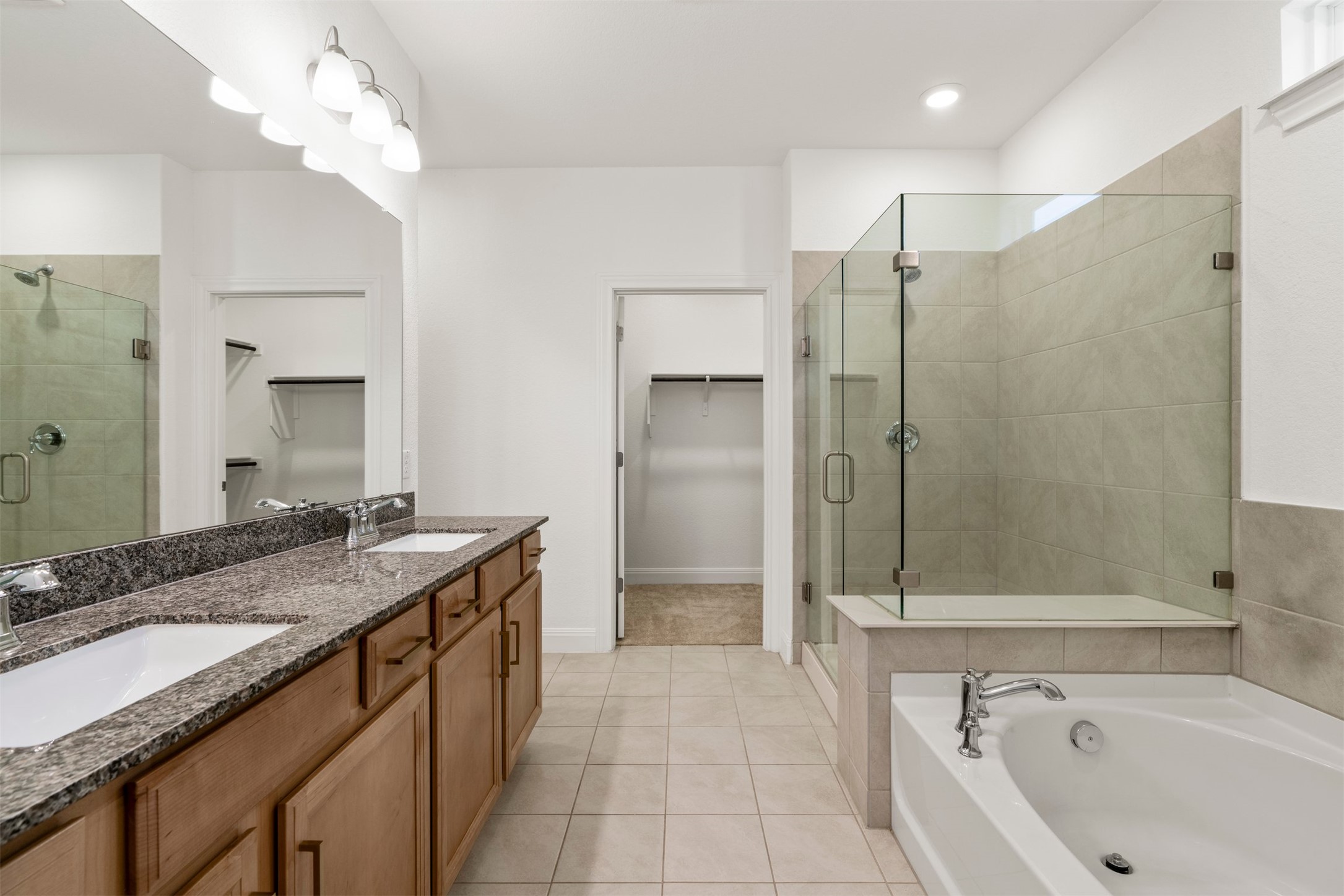 302 Barn Hill Loop Dripping Springs, TX 78620 - Photo 20 of 40 a bathroom with a sink double vanity granite tub shower and a mirror