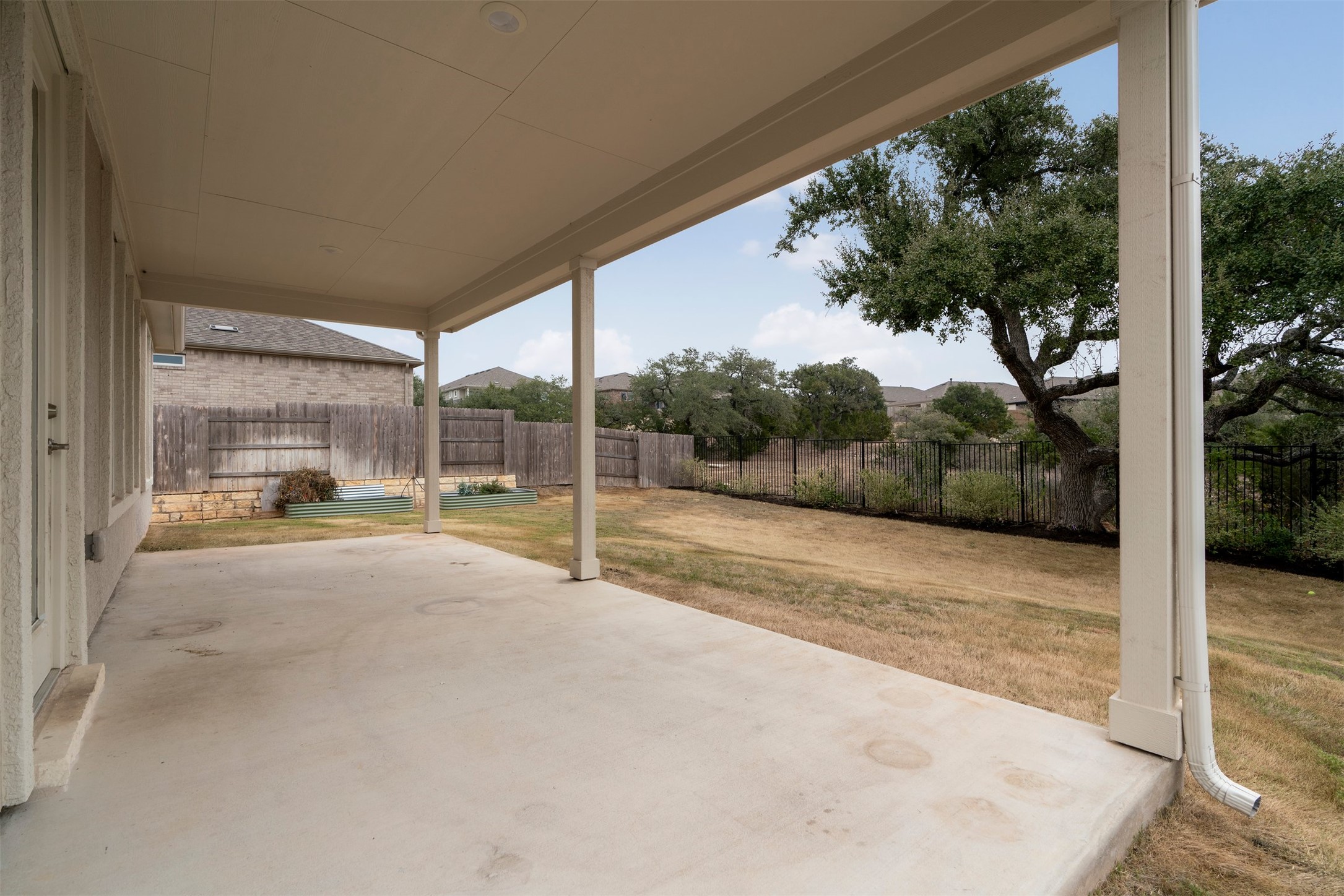302 Barn Hill Loop Dripping Springs, TX 78620 - Photo 7 of 40 The extended covered back patio creates a shaded outdoor living space that looks out over the backyard and surrounding Hill Country landscape