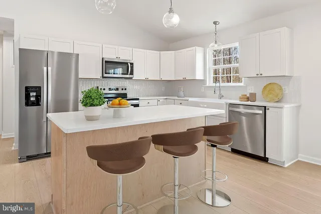 a kitchen with a refrigerator a stove a sink and a microwave