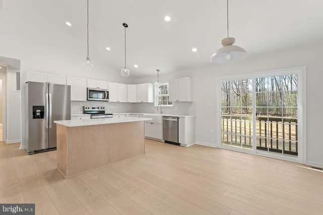 a kitchen with stainless steel appliances a refrigerator a stove a sink and a center island