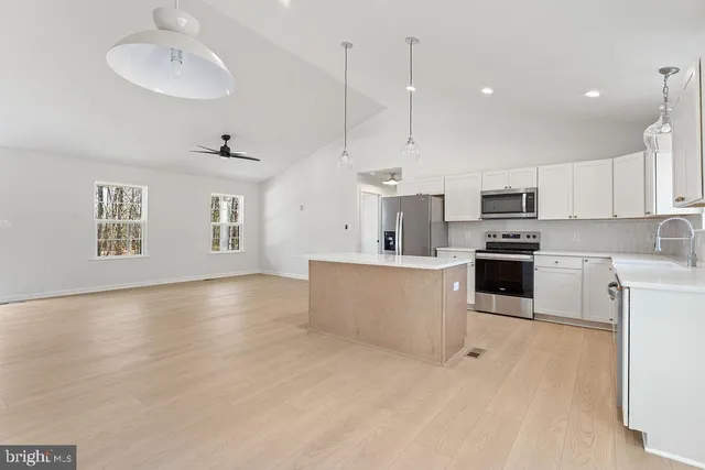 a kitchen with kitchen island a sink stainless steel appliances and cabinets