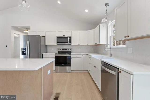 a kitchen with white cabinets and appliances
