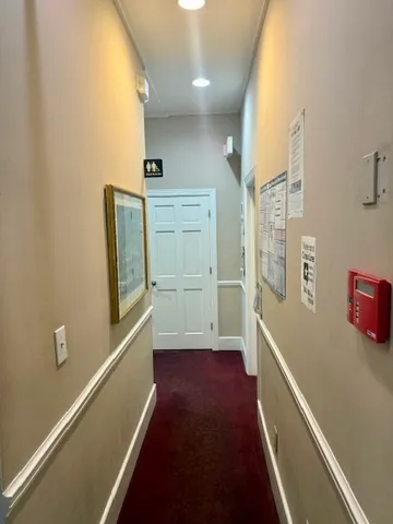 a view of hallway with furniture and wooden floor