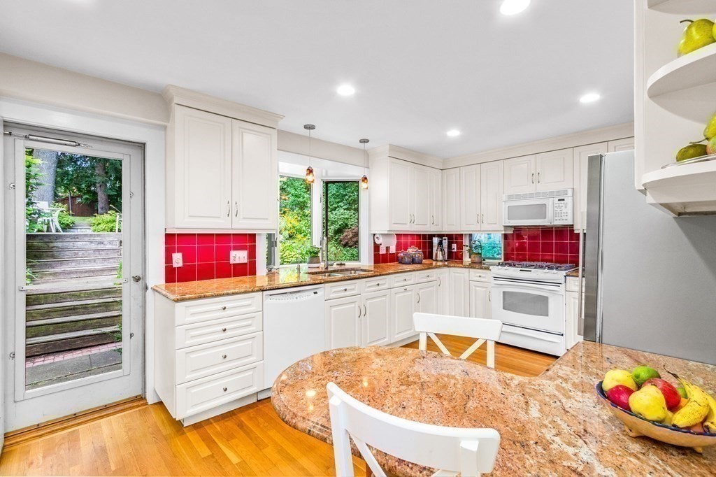 27 Whitney Road Newton, MA 02460 - Photo 12 of 32 a kitchen with stainless steel appliances kitchen island granite countertop a stove and a refrigerator