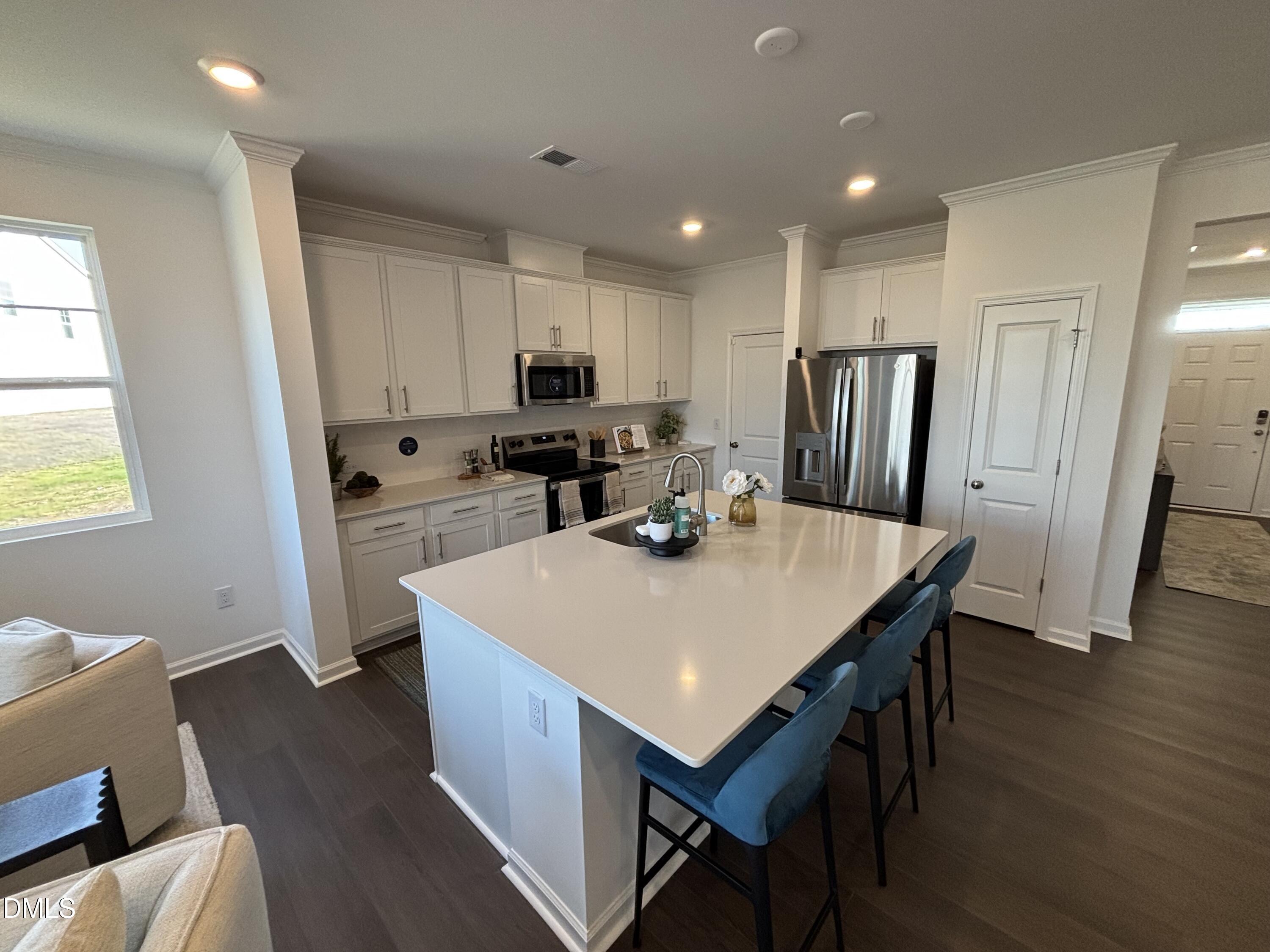 162 Blossom Fld Way Angier, NC 27501 - Photo 3 of 45 a kitchen with stainless steel appliances a kitchen island hardwood floor sink stove refrigerator and cabinets