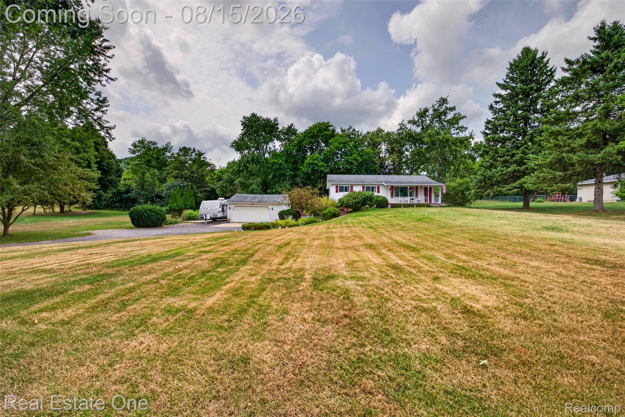 454 South Baldwin Road Oxford, MI 48371 - Photo 38 of 64 Expansive front lawn leading to a single-story residence with a covered porch, attached garage, and mature perimeter trees