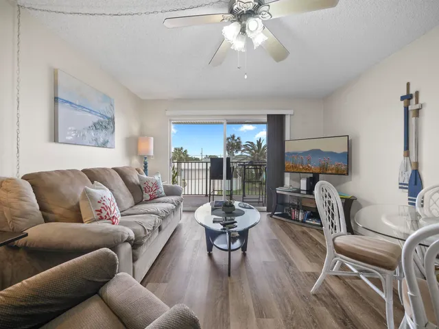 a living room with furniture a dining table and a chandelier