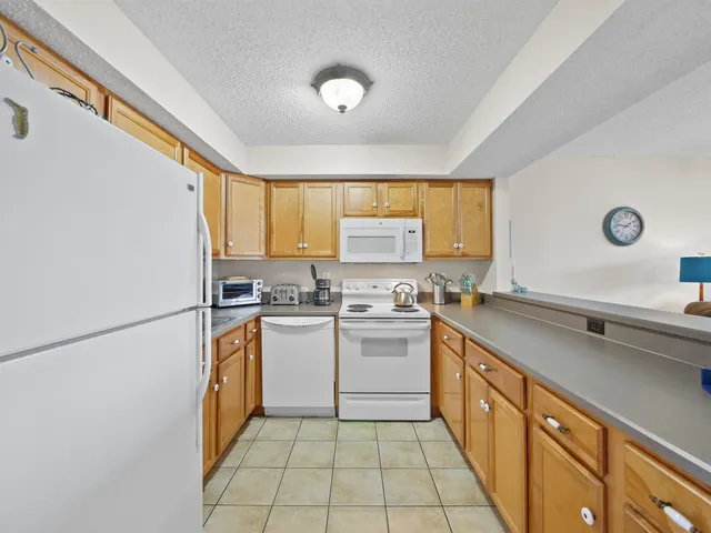 a kitchen with a sink appliances cabinets and a window