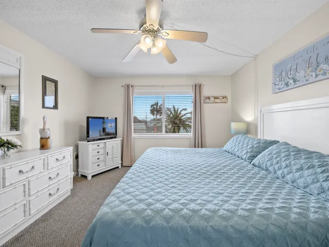 a bedroom with a large bed and a flat tv screen on dresser
