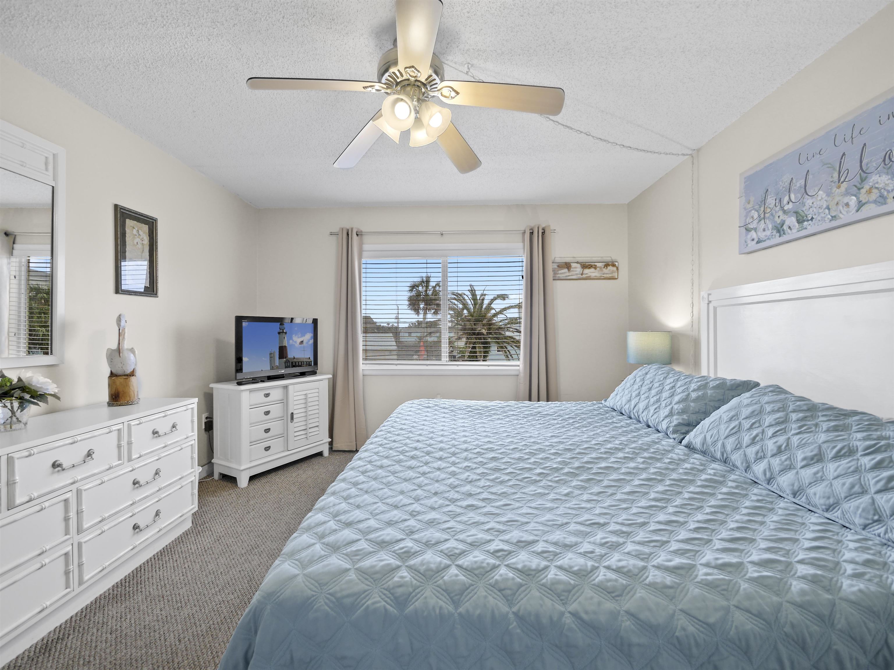 7175 A1A South St. Augustine, FL 32080 - Photo 19 of 35 a bedroom with a large bed and a flat tv screen on dresser