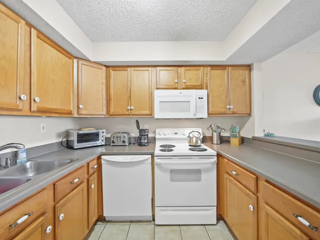 a kitchen with white cabinets sink and appliances
