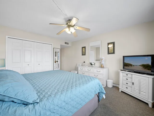 a spacious bedroom with a bed and a flat screen tv