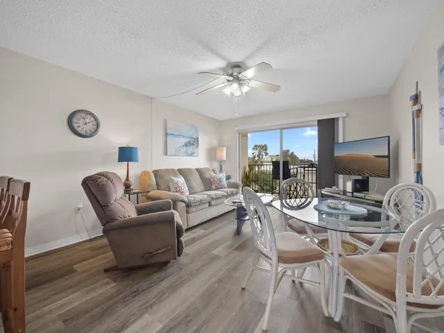 a living room with furniture a clock on wall and a window