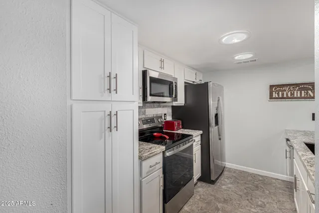 a kitchen with stainless steel appliances a refrigerator stove and microwave